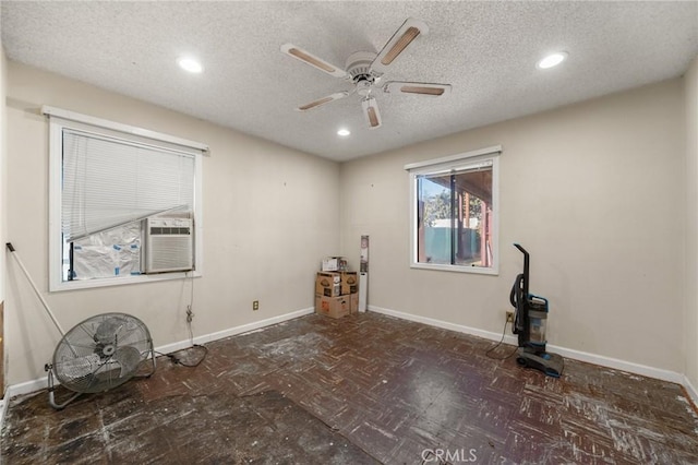 spare room featuring a textured ceiling, ceiling fan, and cooling unit