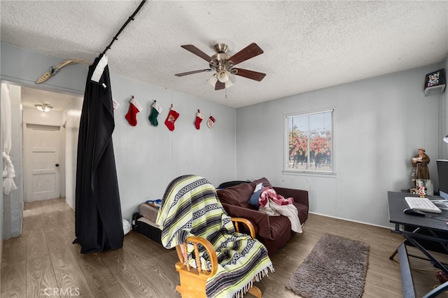 interior space with hardwood / wood-style flooring, a textured ceiling, and ceiling fan