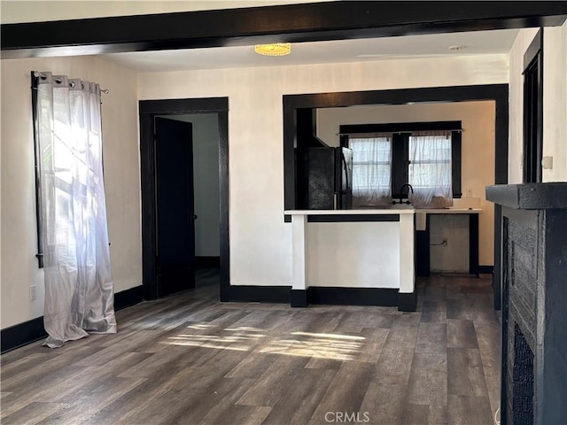 kitchen featuring black fridge and dark hardwood / wood-style flooring