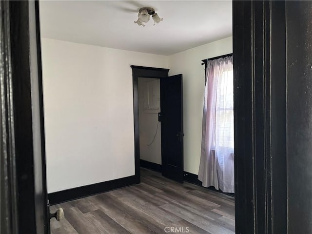 unfurnished room with dark wood-type flooring