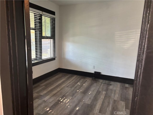 unfurnished room with dark hardwood / wood-style flooring and plenty of natural light