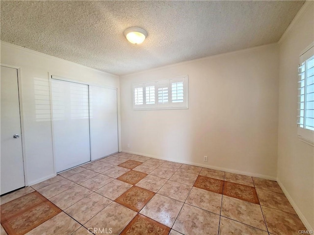 unfurnished bedroom featuring light tile patterned floors, a closet, crown molding, and a textured ceiling