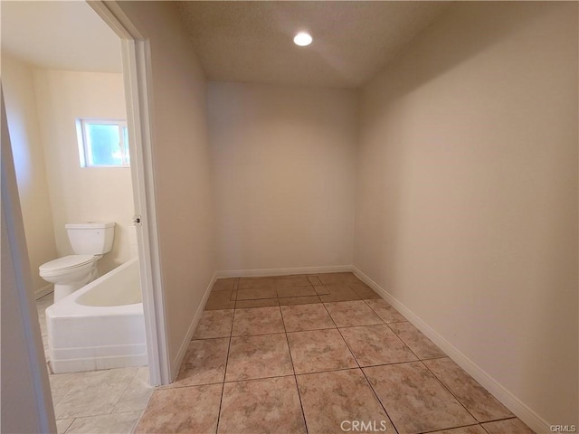 bathroom featuring toilet, tile patterned floors, and a bathing tub