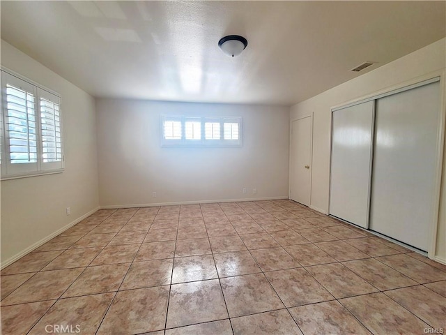 unfurnished bedroom with light tile patterned floors and a closet