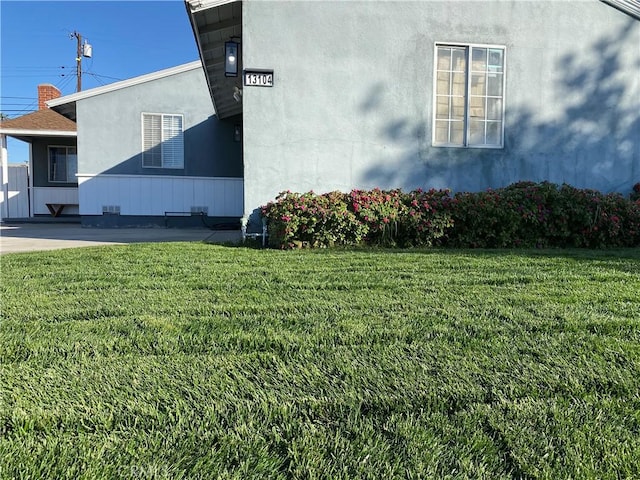 view of side of home with a lawn