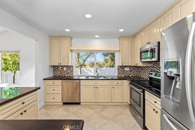 kitchen featuring light tile patterned floors, stainless steel appliances, tasteful backsplash, and sink