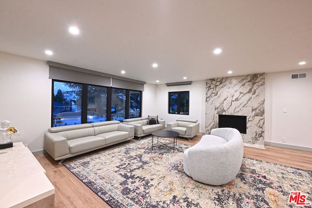 living room with a premium fireplace and light hardwood / wood-style floors