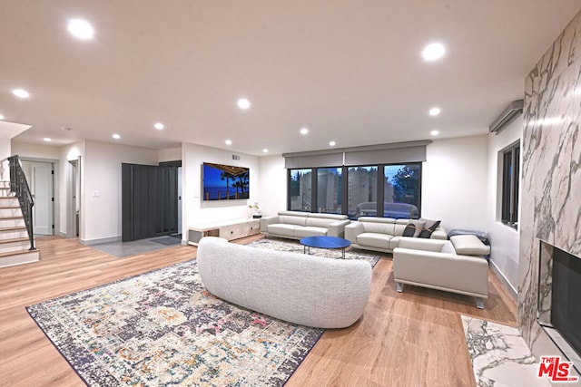 living room with light wood-type flooring and a fireplace