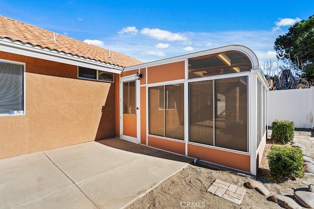 rear view of house with a patio and a sunroom