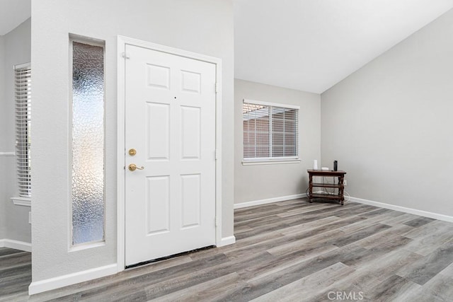 foyer entrance with lofted ceiling and light hardwood / wood-style floors