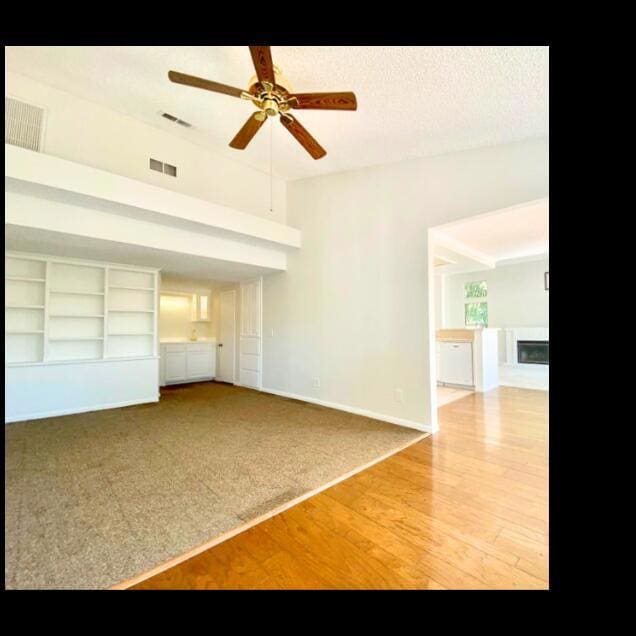 unfurnished living room with ceiling fan and hardwood / wood-style floors