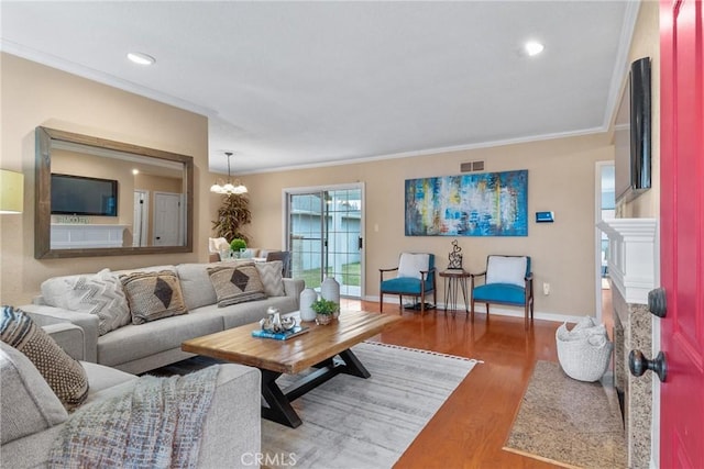 living room with crown molding, an inviting chandelier, and hardwood / wood-style floors