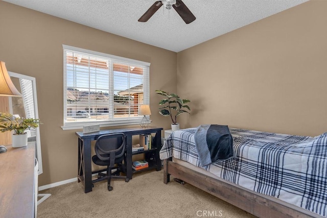 carpeted bedroom with ceiling fan and a textured ceiling