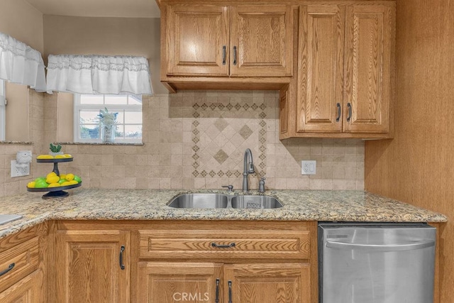 kitchen with sink, backsplash, dishwasher, and light stone counters