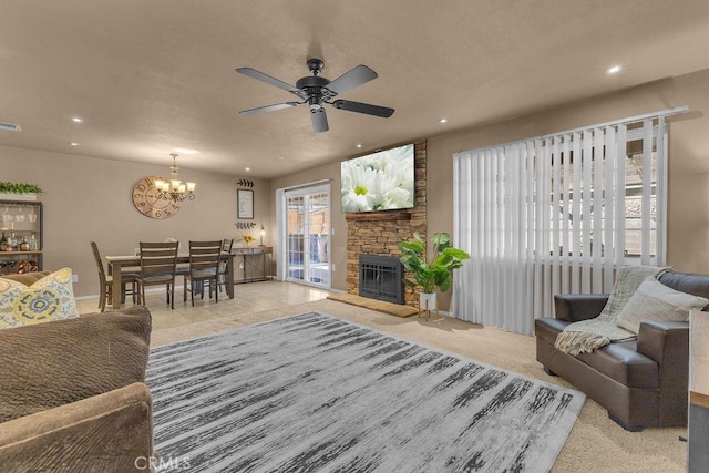 tiled living room with ceiling fan with notable chandelier and a stone fireplace