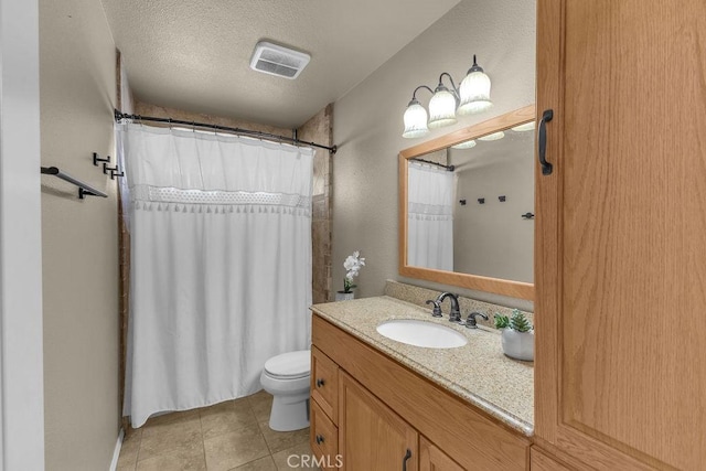 bathroom with vanity, toilet, and a textured ceiling