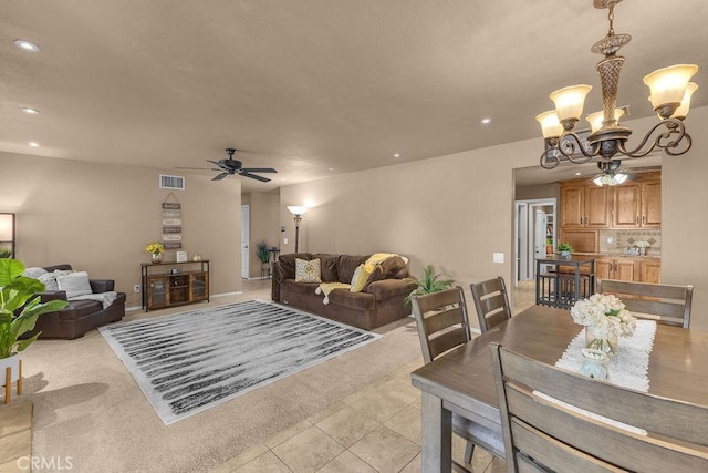 tiled living room featuring ceiling fan with notable chandelier