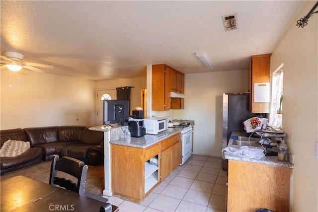 kitchen featuring ceiling fan, light tile patterned floors, plenty of natural light, and white appliances