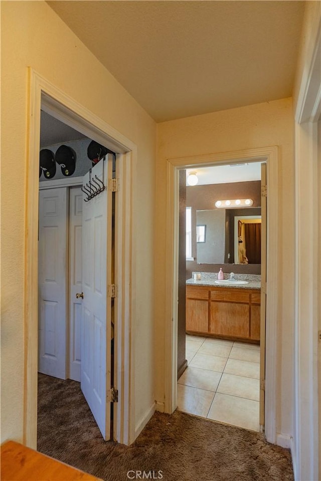 hallway featuring sink and light carpet