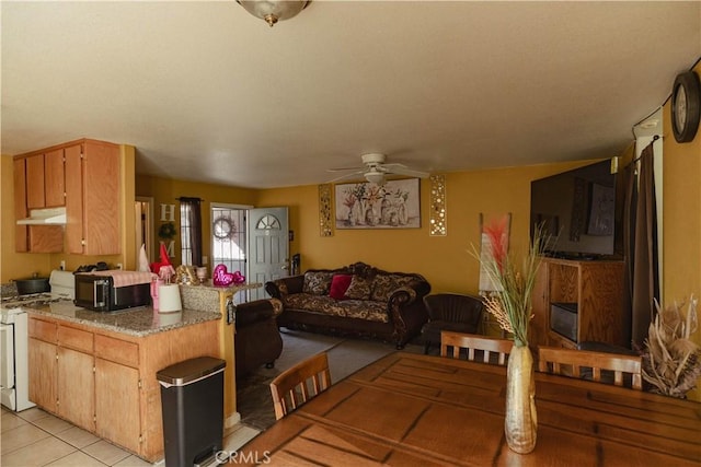 kitchen with light tile patterned flooring, ceiling fan, and white gas stove