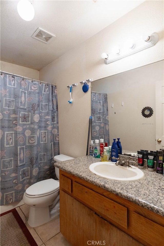 bathroom featuring toilet, tile patterned flooring, and vanity