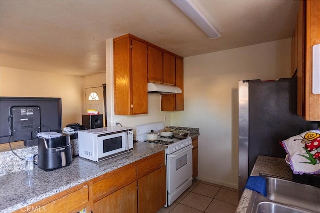 kitchen featuring light tile patterned floors, sink, and white appliances