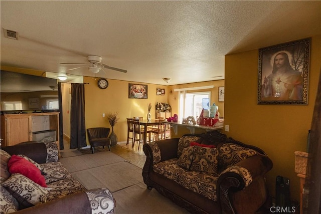 living room with a textured ceiling and ceiling fan