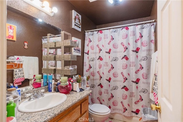 bathroom featuring toilet, vanity, and curtained shower