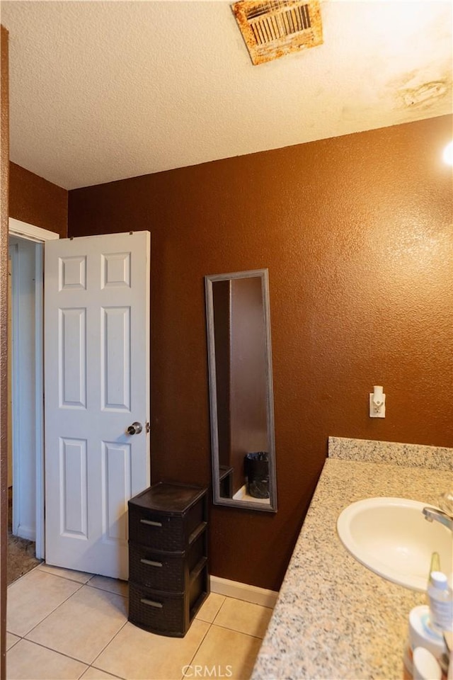 bathroom featuring vanity, tile patterned floors, and a textured ceiling