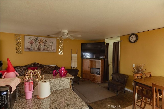 living room with ceiling fan and a textured ceiling