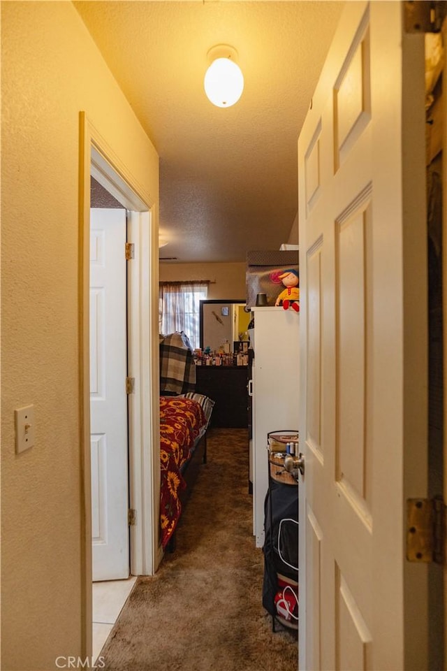 hall featuring carpet floors and a textured ceiling