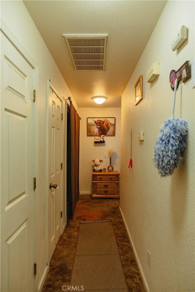 hall with a textured ceiling