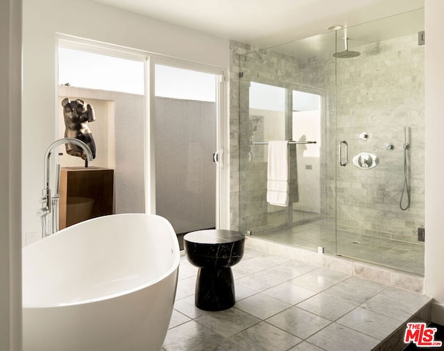 bathroom with tile patterned floors and independent shower and bath