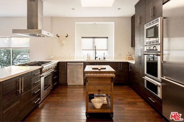 kitchen with dark wood-type flooring, island range hood, a wealth of natural light, and high quality appliances