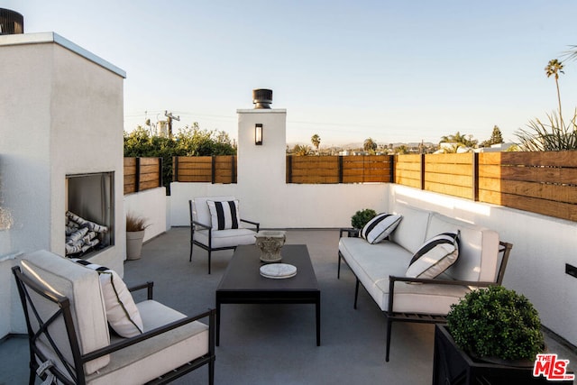 patio terrace at dusk featuring an outdoor living space