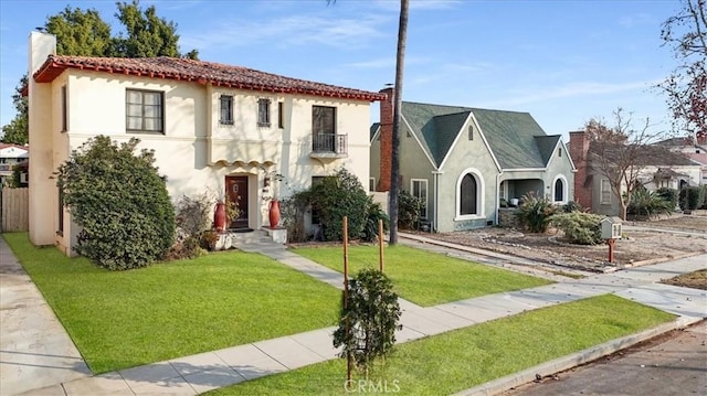 mediterranean / spanish home with a balcony and a front yard