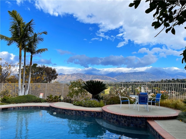 view of swimming pool with a mountain view and a patio area