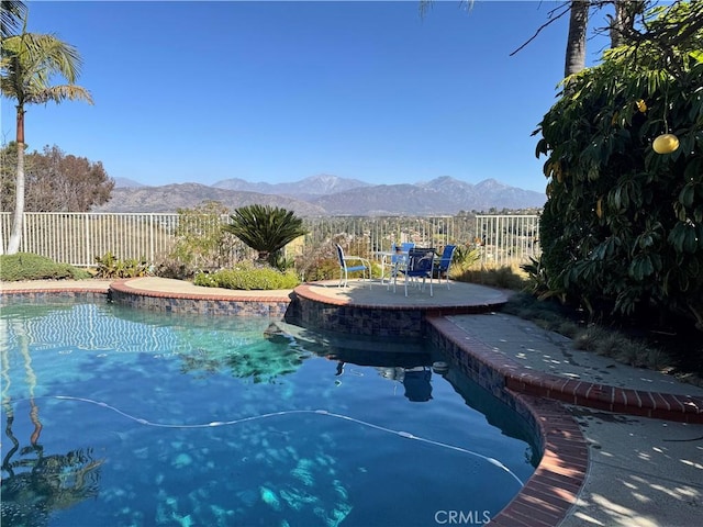 view of swimming pool with a mountain view and a patio