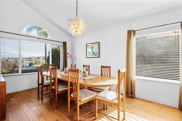 dining room with a notable chandelier, lofted ceiling, and light wood-type flooring