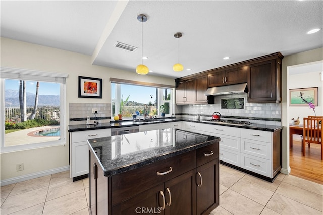 kitchen featuring sink, appliances with stainless steel finishes, a mountain view, a kitchen island, and white cabinets