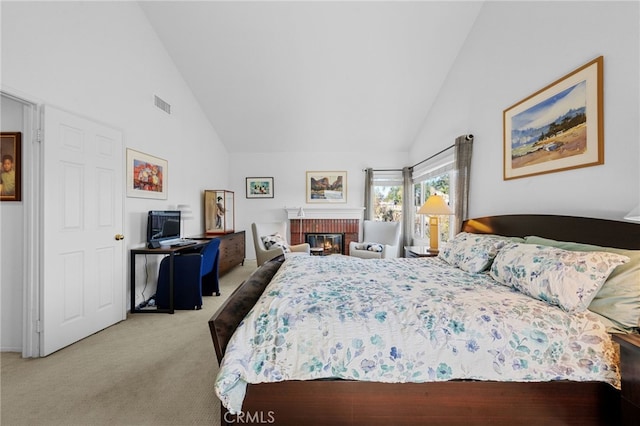 bedroom with light carpet, a brick fireplace, and high vaulted ceiling