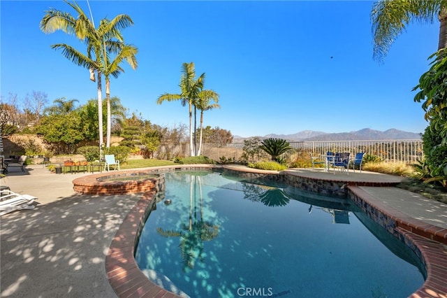 view of pool featuring an in ground hot tub, a mountain view, and a patio area