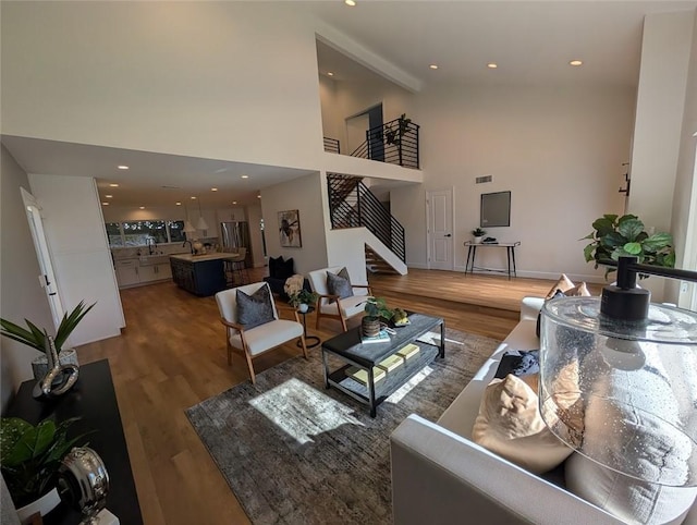 living room with high vaulted ceiling, wood-type flooring, and beam ceiling