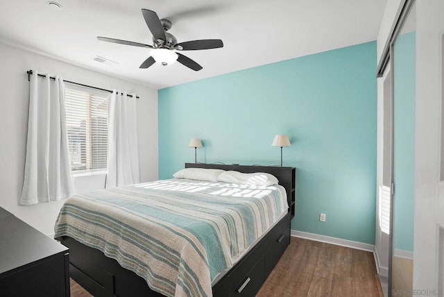 bedroom featuring dark wood-type flooring, ceiling fan, and a closet