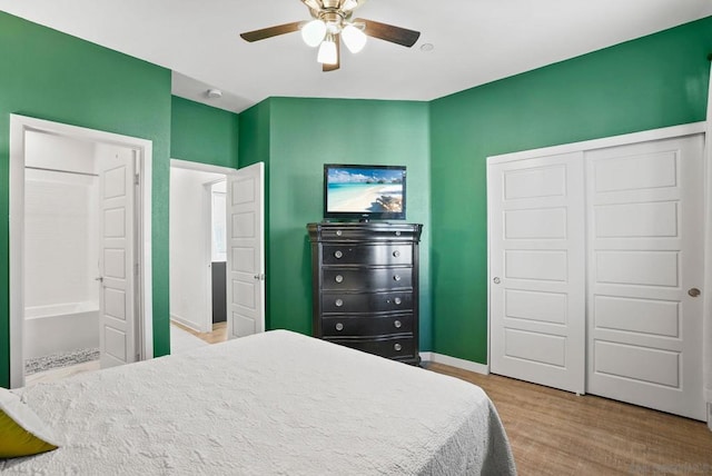 bedroom with ceiling fan, connected bathroom, and light wood-type flooring