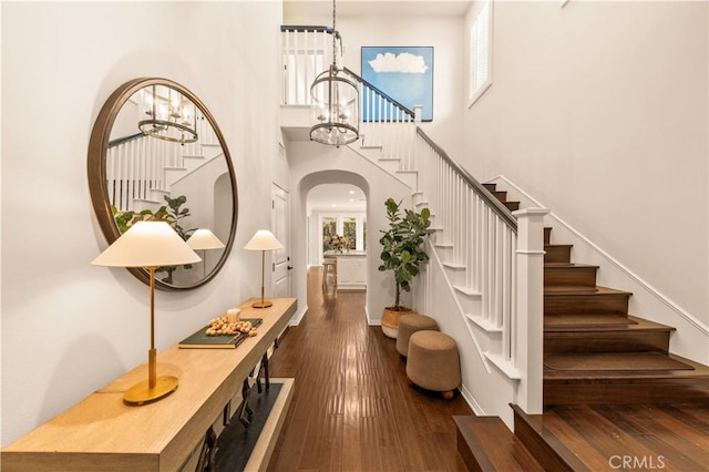 entryway with dark hardwood / wood-style flooring, a high ceiling, and a notable chandelier