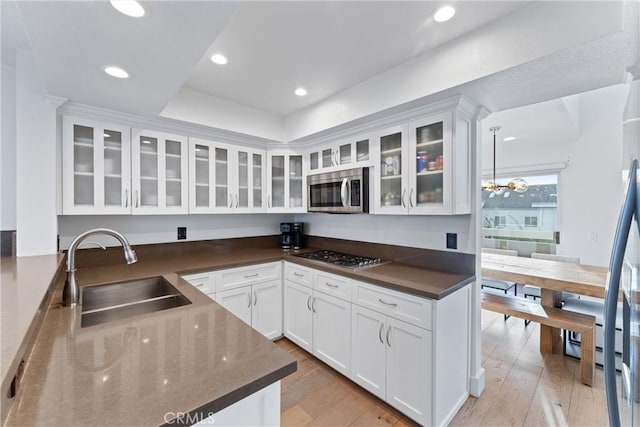 kitchen featuring sink, stainless steel appliances, white cabinetry, and light hardwood / wood-style floors