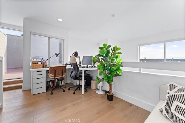 office space with light wood-type flooring and a healthy amount of sunlight