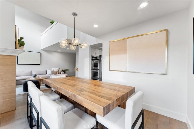 dining area featuring light hardwood / wood-style flooring and a chandelier