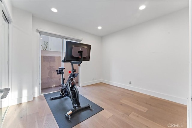 workout area with light hardwood / wood-style flooring